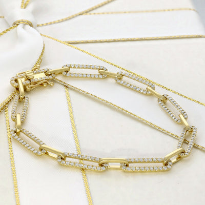Gold bracelets with diamond accents on a white background