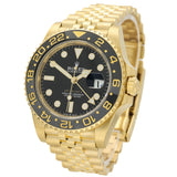 Rolex Submariner Date watch in yellow gold with a black dial and black rotating bezel, featuring a gold Oyster bracelet on a white background.